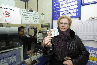 Una mujer muestra ayer un décimo de lotería en una administración de la capital soriana. / VALENTÍN GUISANDE-