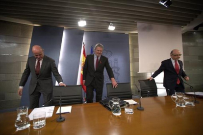 Los ministros Guindos, Méndezde Vigo y Montoro, momentos antes de iniciar la rueda de prensa posterior al Consejo de Ministros de ayer.-DAVID CASTRO