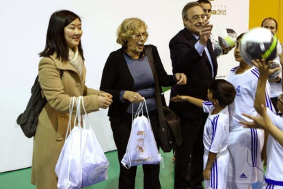 Manuela Carmena, alcaldesa de Madrid, y Florentino Pérez, durante la entrega de obsequios a unos niños.-EFE