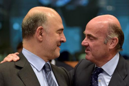 El comisario europeo de Finanzas, Pierre Moscovici, y el español Luis de Guindos, ayer en Bruselas.-REUTERS / ENRIC VIDAL