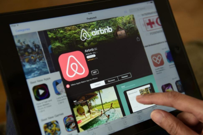 Una mujer navega por la página de Airbnb en una tablet, en Berlín.-