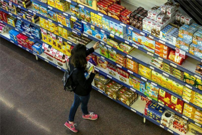 Una mujer realiza la compra en un supermercado.-JOAN