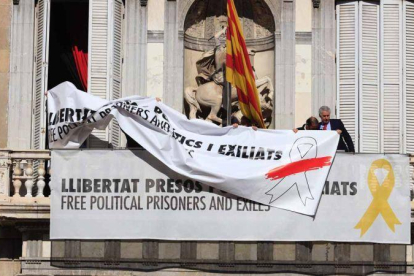 Momento en el que se cambia la pancarta con el lazo amarillo por otra con un lazo blanco en la Generalitat.-FERRAN NADEU