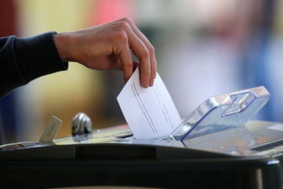 Un votante introduce la papeleta en el referéndum en Irlanda sobre la reforma del aborto.-REUTERS / MAX ROSSI