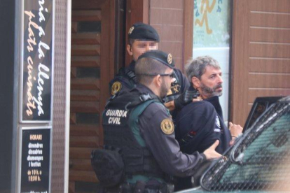 Dos agentes de la Guardia Civil se llevan un detenido en Sabadell en el marco de la operación que ha acabado con nueve miembros de CDR arrestados.-MIQUEL CODOLAR