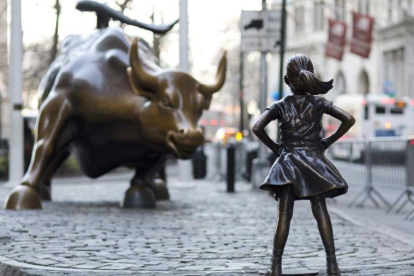 La niña de bronce frente al toro de Wall Street.-AP / MARK LENNIHAN