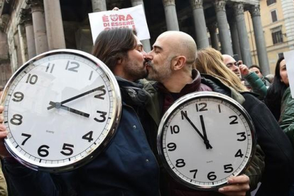 Una pareja con dos grandes relojes en la manifestación de Roma.-AFP / ALBERTO PIZZOLI