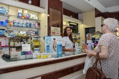 Una clienta compra medicamentos en una farmacia.-EL PERIÓDICO