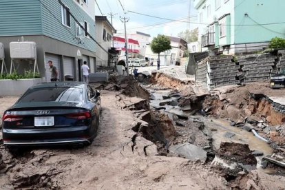 Un vehiculo permanece atrapado entre el lodo en una calle destruida tras el fuerte terremoto.-EFE