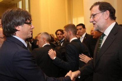 El 'president' Puigdemont saluda a Rajoy durante una inauguración de una exposición sobre Joan Miró en Oporto (Portugal).-JORDI BEDMAR