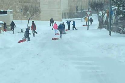 Niños y algunos mayores aprovechando la nieve para jugar en Golmayo, donde la población contribuyó a limpiar las calles con el Ayuntamiento.-HDS