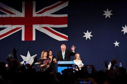 El primer ministro australiano Scott Morrison celebra su victoria en Melbourne con su mujer y sus dos hijas.-DEAN LEWINS (EFE)