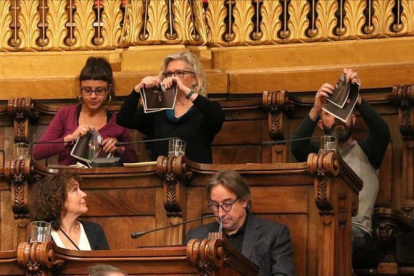 Los concejales de la CUP en el Ayuntamiento de Barcelona, Maria Rovira, María José Lecha y Josep Garganté, rompen fotos del Rey durante un pleno municipal.-ACN