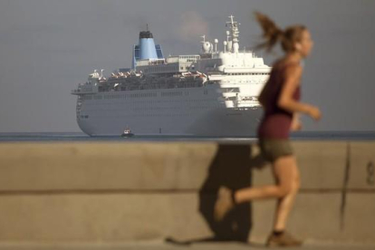 Una mujer corre por el Malecón mientras el crucero Thomson Dream llega a La Habana, el 19 de marzo.-AP / DESMOND BOYLAN