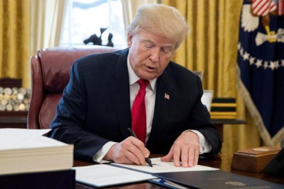 Trump firma la ley sobre la reforma fiscal, en el Despacho Oval de la Casa Blanca, en Washington, el 22 de diciembre.-EFE / MICHAEL REYNOLDS