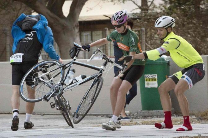 Ciclistas luchan contra el fuerte viento para que sus bicicletas no salgan volando.-AFP / RODGER BOSCH