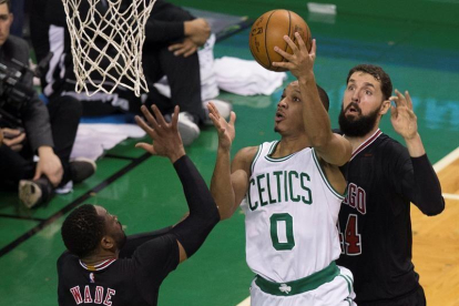 El jugador de Celtics Avery Bradley (c) se dirige a canasta ante la marca de Dwyane Wade (i) y Nikola Mirotic (d), de los Bulls.-EFE