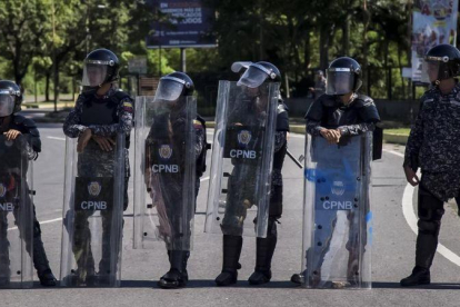 Integrantes del Cuerpo de Policía Nacional Bolivariana (CPNB) vigilan en una calle durante una manifestación de apoyo a un grupo de militares sublevados, el 6 de agosto.-EFE