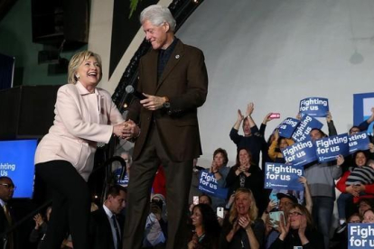 La candidata demócrata Hillary Clinton junto a su marido, expresidente de EEUU, en el caucus en Davenport (Iowa).-AFP / JUSTIN SULLIVAN