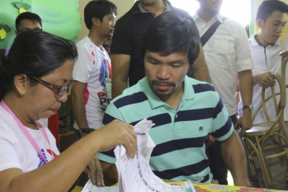 El boxeador Emmanuel Manny "Pacman" Pacquiao (d) ejerce su derecho al voto en Kiam.-KIM TIBLANI / EFE