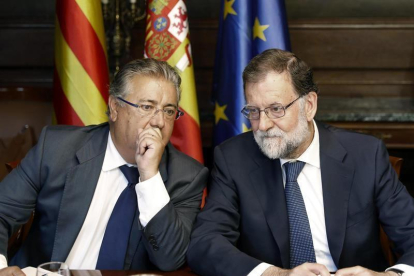El jefe del Ejecutivo, Mariano Rajoy (d), y el ministro del Interior, Juan Ignacio Zoido (i), durante la reunión con responsables de las Fuerzas de Seguridad del Estado para analizar la situación tras los atentados en Barcelona y Cambrils.-EFE / ANDREU DALMAU
