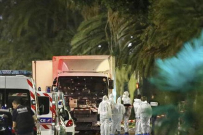 Un grupo de forenses examinan el camión del atentado, anoche en Niza.-
