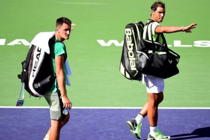 Nadal y Tomic se despiden de la afición tras perder el partido de dobles.-AFP / HARRY HOW