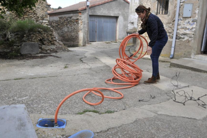 Una vecina de Fuentes muestra el sistema de suministro de agua con una manguera-V.G.