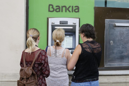 Usuarios de Bankia utilizan un cajero de la entidad en Barcelona.-EL PERIÓDICO / ARCHIVO
