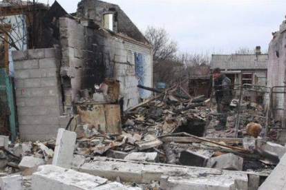 Un rebelde prorruso camina entre edificios destruidos en una calle de Donetsk, este martes.-Foto: EFE / PHOTOMIG
