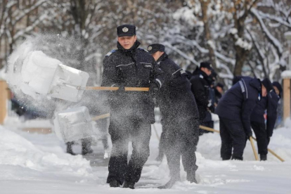 Gendarmes rumanos limpian la nieve en los accesos a una escuela en Bucarest.-AP / VADIM GHIRDA