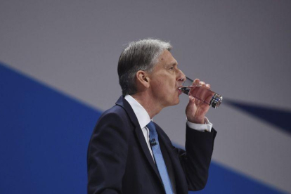 El ministro británico de Economía, Philip Hammond, bebe agua durante su discurso en el congreso anual del Partido Conservador en Birmingham.-FACUNDO ARRIZABALAGA / EFE