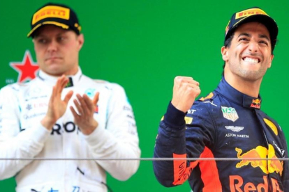 El australiano Daniel Ricciardo (Red Bull) celebra su victoria en China al subir al podio, ante el aplauso de Valtteri Bottas (Mercedes), segundo.-REUTERS / ALY SONG