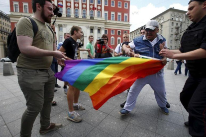 Manifestantes homófobos tratan de romper una bandera gay de un grupo de homosexuales en Moscú-MAXIM ZMEYEV (REUTERS)