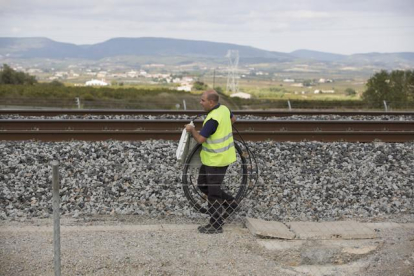 Operarios y mossos en el lugar donde se produjo el sabotaje del AVE, en la Granada del Penedès.-ALBERT BERTRAN