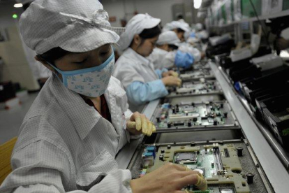 Trabajadores en una planta de Foxconn en Shenzhen, China.-