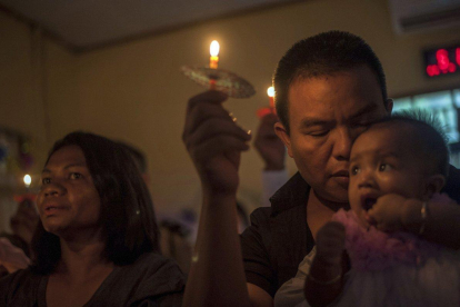 People attend a Christmas service at Rahmat Pentecostal Church in Carita  Indonesia  Christmas celebrations traditionally filled with laughter and uplifting music were replaced by somber prayers for tsunami victims in Indonesia-Fauzy Chaniago  / AP