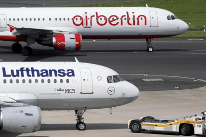 Foto de archivo de un avión de la aerolínea Lufthansa y otro de Air Berlin en el aeropuerto de Dusseldorf.-FRIEDEMANN VOGEL/EFE