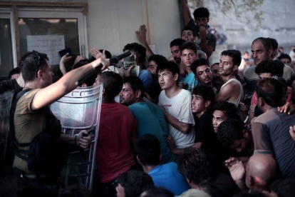 La policía helena carga contra los inmigrantes que esperan para registrarse en el puerto de Mitelene, en la isla de Lesbos.-AFP / ANGELOS TZORTZINIS