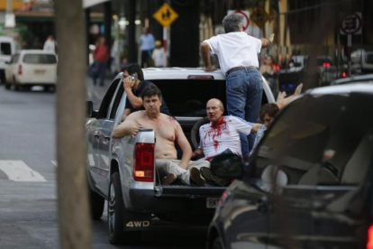Efraín Alegre, líder del Partido Liberal (izquierda), junto a un herido en los disturbios de la madrugada del sábado en Asunción.-JORGE SAENZ