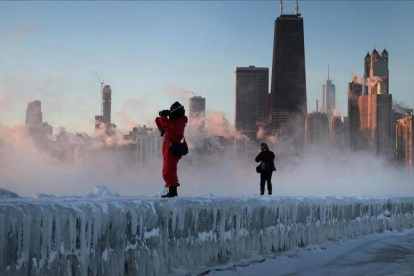 Dos fotógrafos toman imágenes de la tormenta sobre la ciudad de Chicago.-AFP / SCOTT OLSON