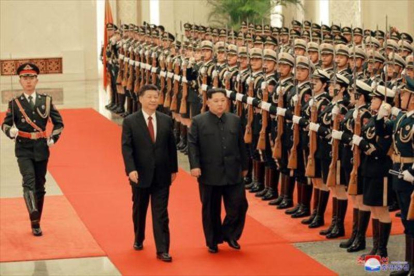 Kim Jong-un y Xi Jinping pasan revista a la guardia de honor en Pekín, en una imagen de archivo.-REUTERS / KCNA