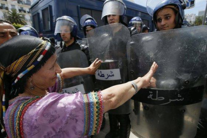 Una mujer protesta frente a la policía en Argel (Argelia).-ANIS BELGHOUL (AP)