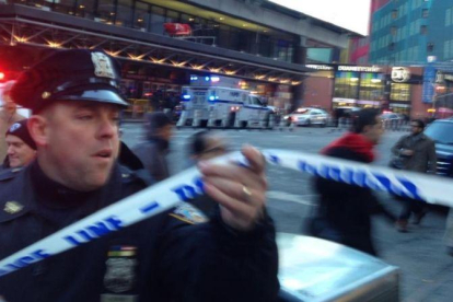 Un policía acoordona los alrededores de la estación de autobuses de Nueva York donde se ha producido la explosión.-CHARLES ZOELLER / AP