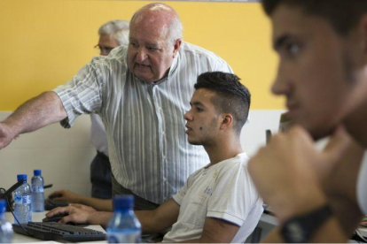 Una persona jubilada enseña de forma voluntaria informática a jóvenes, en La Roca del Vallès (Barcelona).-ALBERT BERTRAN