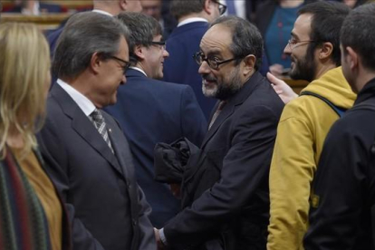 Artur Mas y Antonio Baños se saludan el pasado lunes antes del pleno de constitución del Parlament.-AFP / LLUÍS GENÉ
