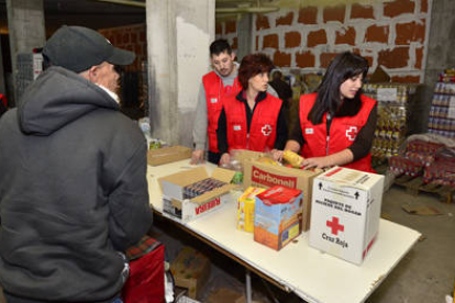 Reparto de comida a personas necesitadas por voluntarios de Cruz Roja. / ÁLVARO MARTÍNEZ-