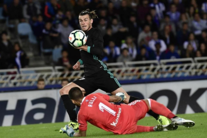 Bale pica el balón ante Rulli para marcar el tercer gol del Madrid en Anoeta.-ÁLVARO BARRIENTOS / AP