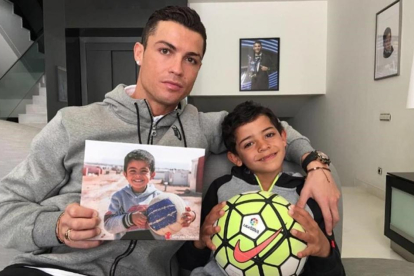 Cristiano Ronaldo ha subido en sus cuentas de Facebook e Instagram una imagen junto a su hijo en la que sostiene una foto de un pequeño sirio.-