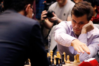 Magnus Carlsen y Fabiano Caruana (de espaldas) durante el desempate o tie-break a partidas rápidas del Mundial de Londres.-AFP / TOLGA AKMEN